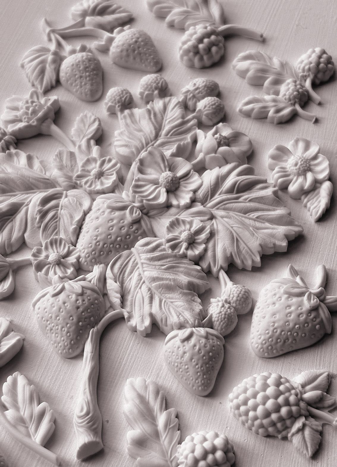 A close up image of white clay castings from Iron Orchid Designs Wild Berries mould.