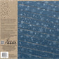Back cover of an Iron Orchid Designs 'With Fox The IOD Family' decorative stamp book, featuring a blue wood-grain panel with white snowflakes on the right and product details, barcode, and branding on the left. Flurry stamp