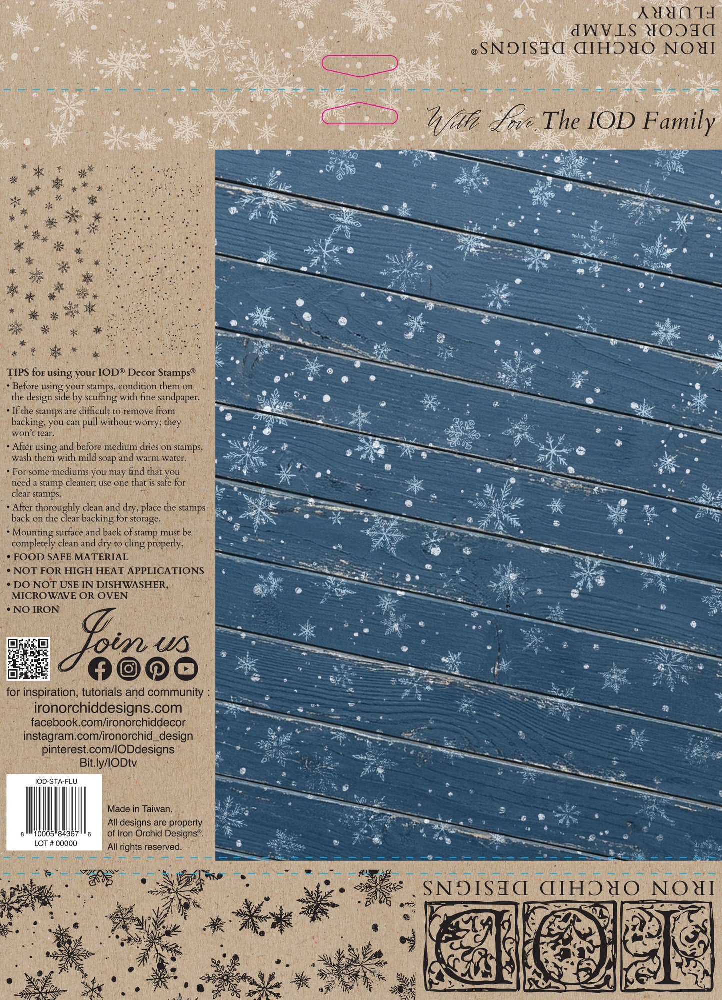 Back cover of an Iron Orchid Designs 'With Fox The IOD Family' decorative stamp book, featuring a blue wood-grain panel with white snowflakes on the right and product details, barcode, and branding on the left. Flurry stamp