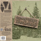 Back packaging of a 'Christmas Evergreen' iron-on design from Iron Orchid Designs, featuring a rustic wooden hanging sign with the words 'CHRISTMAS EVERGREEN' over a green pine forest background, alongside product details and application examples.