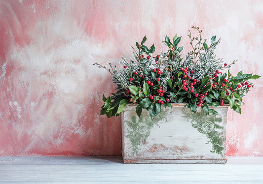 Decorative floral arrangement with red berries in a stamped wooden box against a pink textured background