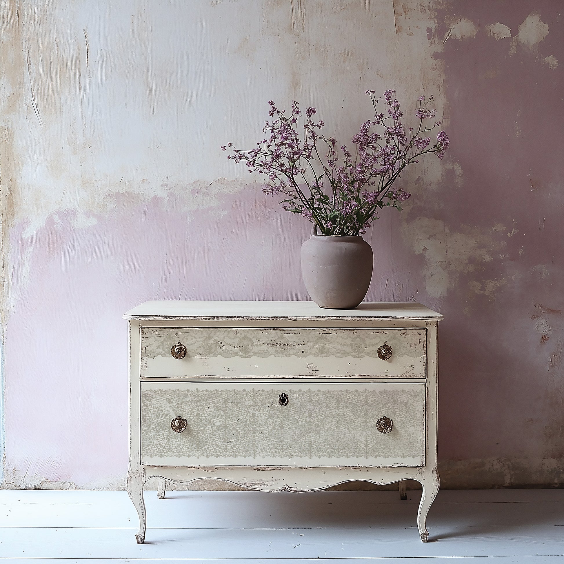 Vintage-style chest of drawers stamped with Iron Orchid Designs Lace Stamp with a vase of flowers against a textured wall.