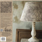 Lamp with textured shade on a wooden surface, surrounded by text and branding elements from the Orleans stamp by Iron Orchid Designs