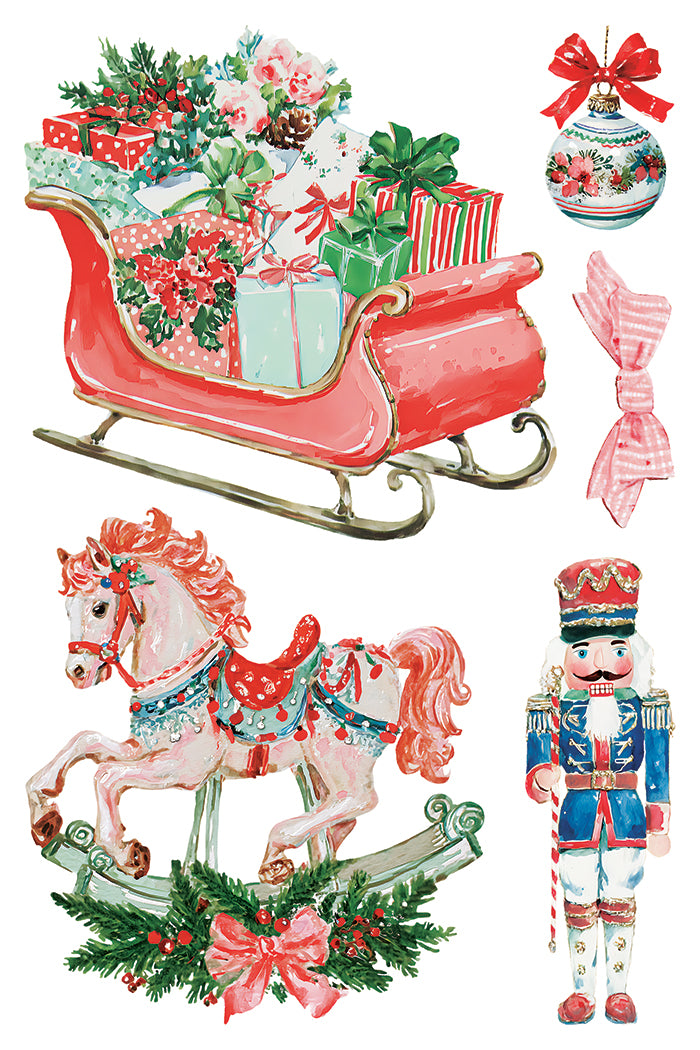 A watercolor-style holiday collage on a white background featuring a red sleigh filled with wrapped gifts, a pink rocking horse with green garland and pink bow, a blue-and-red nutcracker soldier, and a red ornament with a bow. From Iron Orchid Designs.