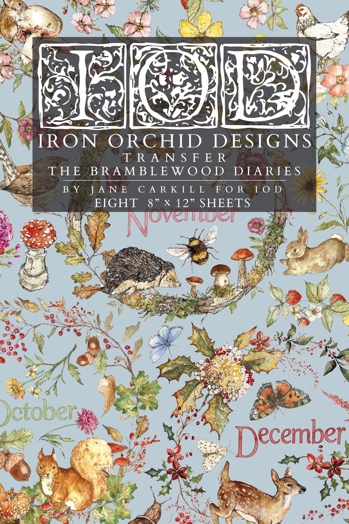 A flat lay of a transfer paper sheet featuring autumn and woodland illustrations, labeled 'IOD Iron Orchid Designs Transfer The Bramblewood Diaries' with months October, November, and December visible. From Iron Orchid Designs