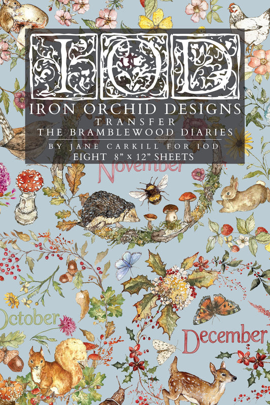 A flat lay of a transfer paper sheet featuring autumn and woodland illustrations, labeled 'IOD Iron Orchid Designs Transfer The Bramblewood Diaries' with months October, November, and December visible. From Iron Orchid Designs
