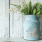 Decorative blue jug with floral design filled with green ferns and white flowers on a wooden surface from Iron Orchid Designs Fern Fables transfer