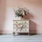 Decorative chest of drawers with floral patterns against a pink wall from Iron Orchid Designs Marche des Fleurs