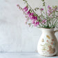 Vintage jug with floral arrangement against a white wall from Iron Orchid Designs Primrose Isle Transfer