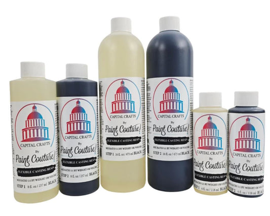 A set of six Capital Crafts by Paint Couture Flexible Casting Resin bottles in various colors, including black, dark blue, and cream, arranged against a plain white background.
