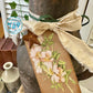 Decorative rusty milk churn with floral design tag 