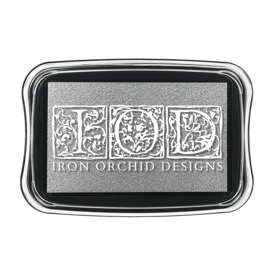 A rectangular metal tray with rounded corners, featuring a textured silver center with the embossed letters 'FOD' in an ornate floral font and the words 'IRON ORCHID DESIGNS' below, set against a plain white background.