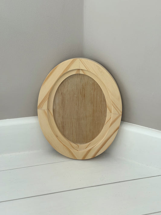 Small oval wooden craft blank on a white surface with a grey background by Iron Orchid Designs
