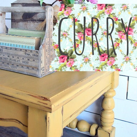 Yellow wooden table with floral border and 'CURRY' text