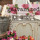 Decorative setting with floral elements and a 'galvanized' sign.