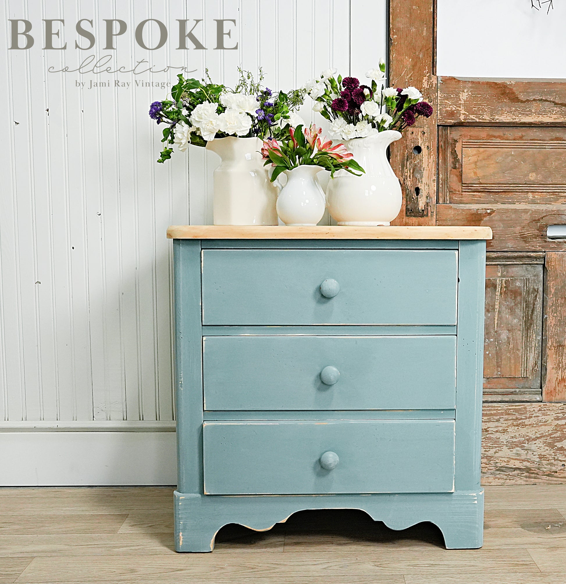 Blue dresser with wooden top against a rustic wooden wall