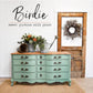 Green chest of drawers with a wooden top standing next to a wooden door.