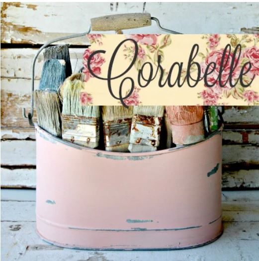 Pale pink metal bucket full of paint brushes 