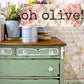 Vintage green dresser with floral decorations and 'oh olive!' text on a rustic background