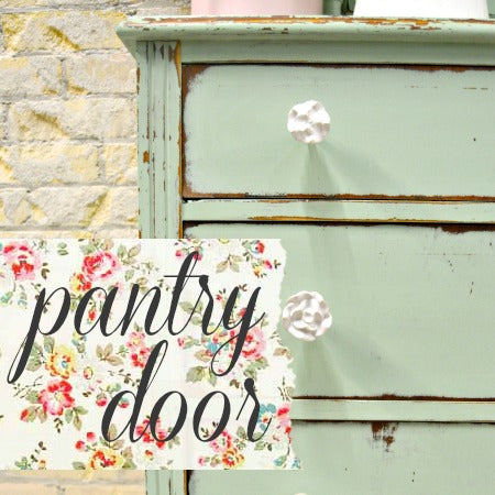 Green wooden pantry door with floral text overlay