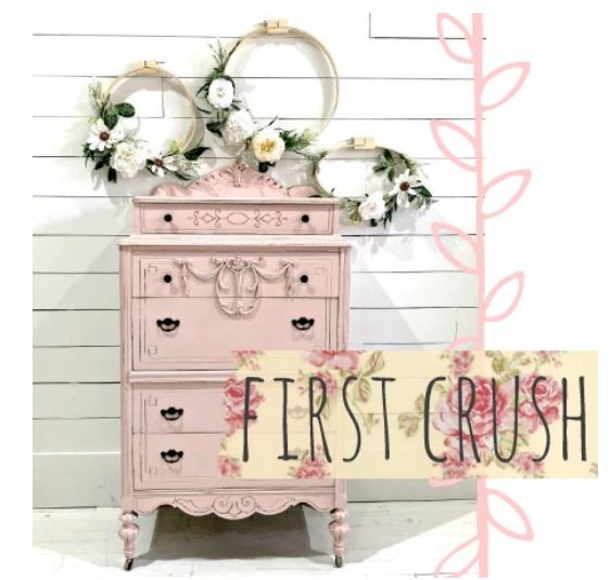 Pink vintage-style dresser with floral decorations against a white wooden background, featuring First Crush milk paint