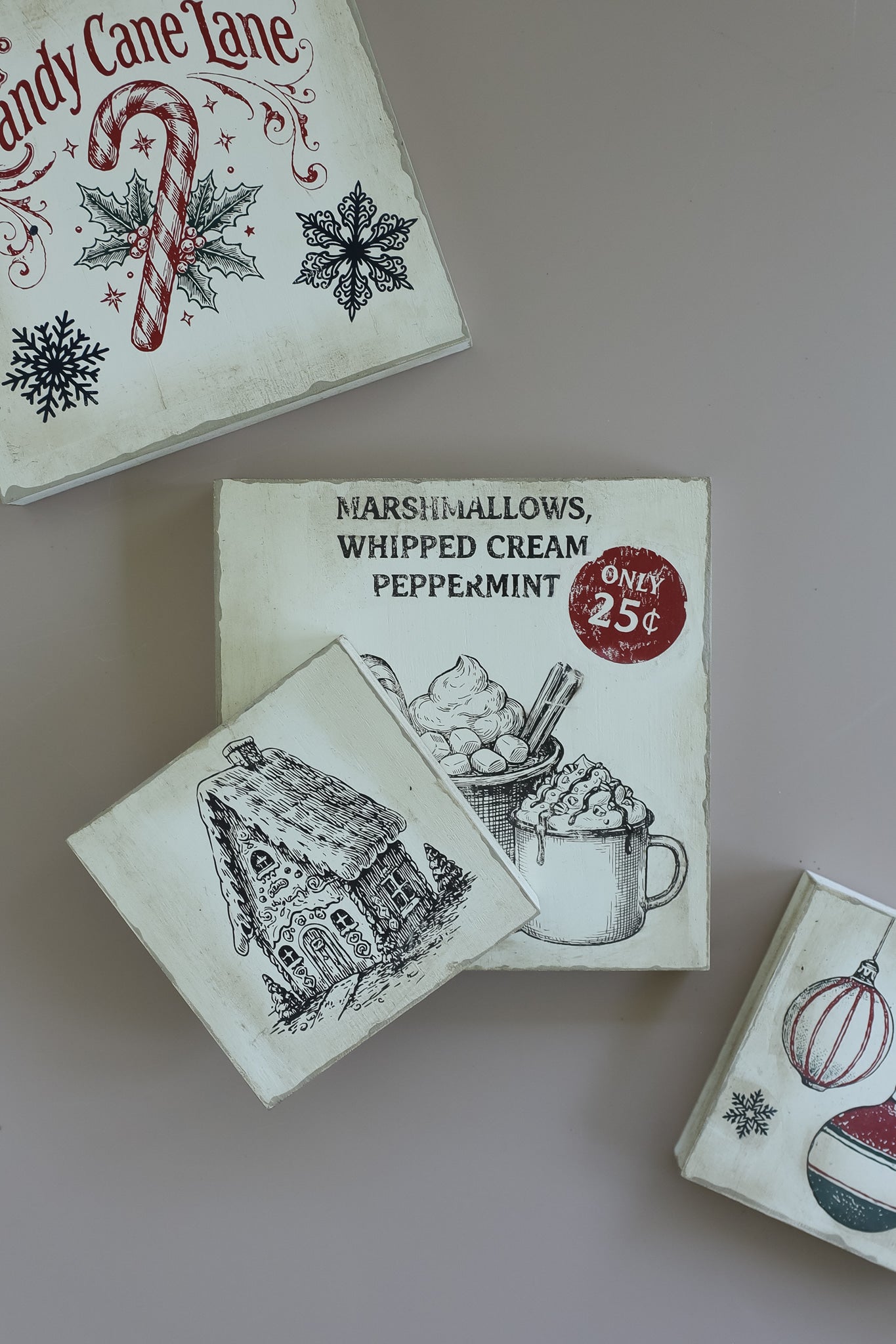 Three vintage-style Christmas-themed matchboxes arranged on a neutral beige background. The center matchbox reads 'Marshmallows, Whipped Cream, Peppermint' and shows a mug illustration with a red 'Only 25c' stamp. From Iron Orchid Designs