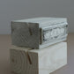 A small decorative wood stand with a distressed white painted top and a carved wood base, photographed against a plain gray background. From Iron Orchid Designs.
