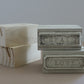 Four decorative rectangular wooden stands on a beige surface against a light gray background. Two boxes are unfinished light wood with visible grain, and two are painted in a distressed off-white finish with embossed labels reading CREATE and LOVE. From Iron Orchid Designs