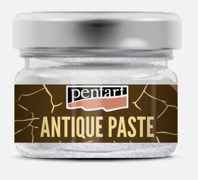 A small clear glass jar of Pentart White Antique Paste with a brushed silver metal lid and a brown label featuring gold crackle details and the brand name 'pentart'.