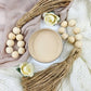 A pot of beige paint on a white cloth next to woven tassels. Paint Couture
