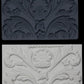 Iron Orchid Designs Acanthus Scroll Mould above white castings of the mould