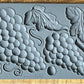 Iron Orchid Designs Grapes grey Mould laying on a wooden surface