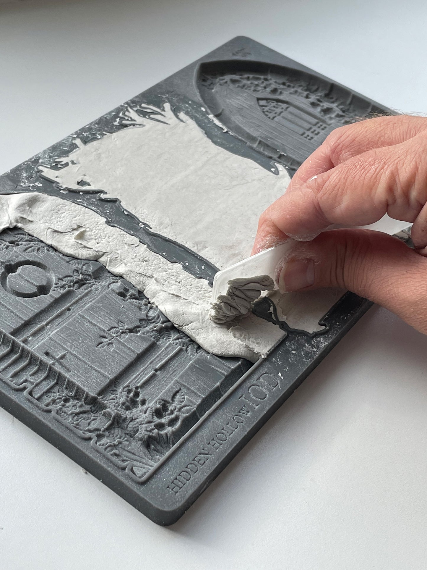Iron Orchid Designs fairy doors Hidden Hollow grey Mould with a close up picture of white clay in the mould