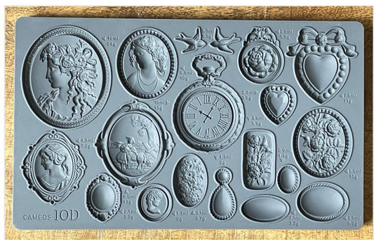 Iron Orchid Designs Cameos Mould. Grey mould laying on a wooden surface. Beautiful intricate designs of cameos, hearts and flowers.