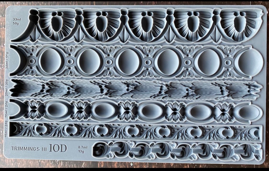 Iron Orchid Designs Trimmings Three decorative trims grey Mould laying on a wooden surface