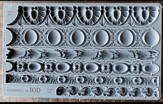 Iron Orchid Designs Trimmings Three decorative trims grey Mould laying on a wooden surface