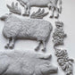 White clay castings from Iron Orchid Designs Village Market Mould showing pig, sheep and cow