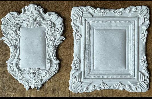 Iron Orchid Designs Frames 2 castings laying on a wooden surface