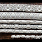 White clay castings from Iron Orchid Designs Trimmings Three decorative trims Mould laying on a wooden surface