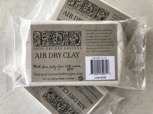 Three blocks of Iron Orchid Designs Air Dry Clay stacked up and wrapped in plastic