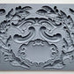 Iron Orchid Designs Olive Crest grey Mould laying on a wooden surface